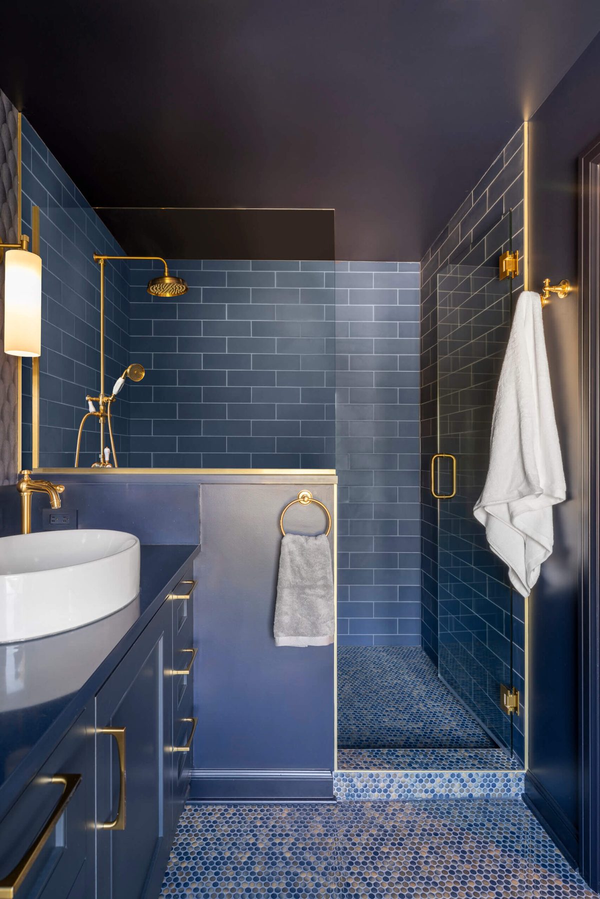 Navy tile shower with brass trim