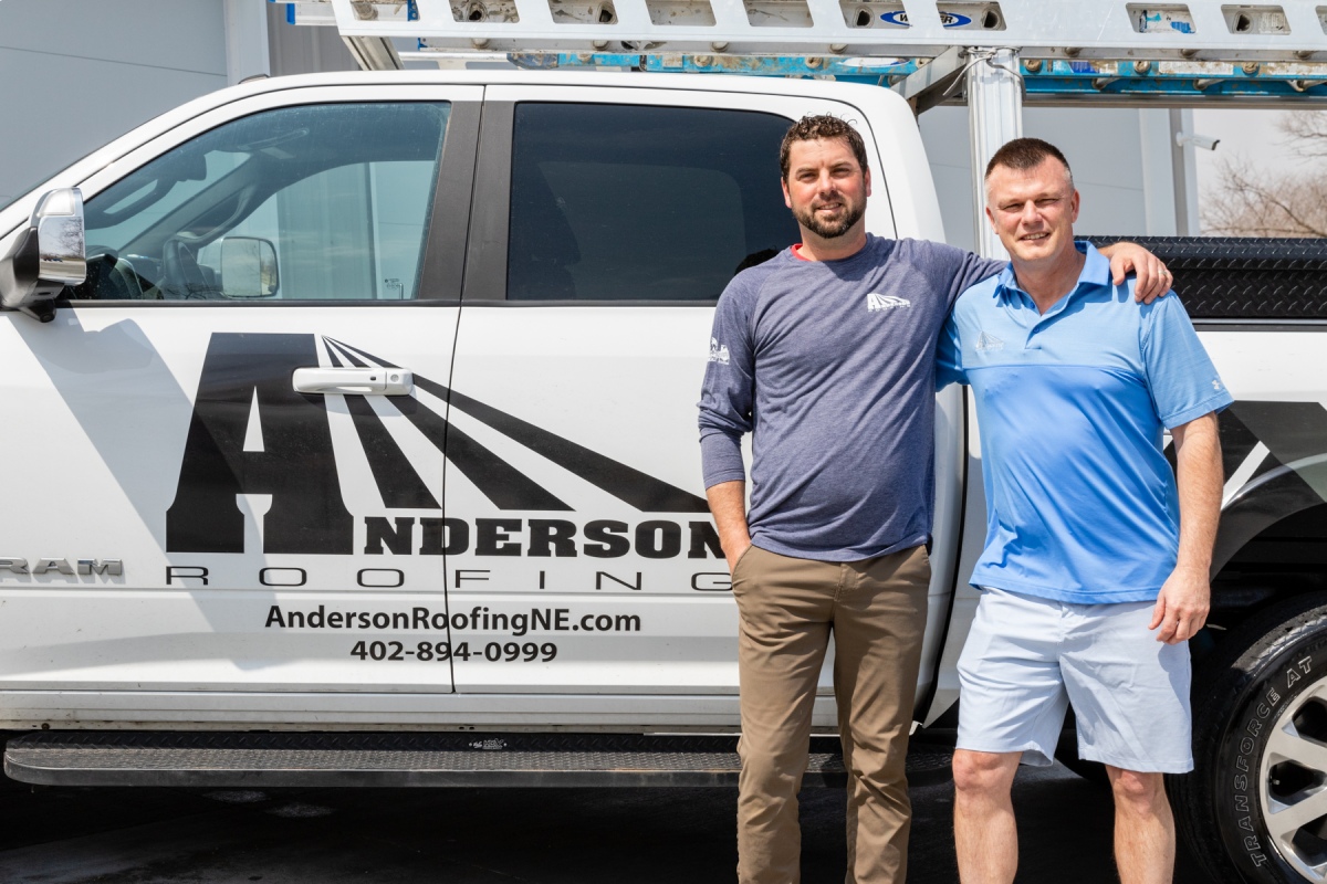 Owners Dave Anderson and Chris Baumgart in front of an Anderson Roofing truck