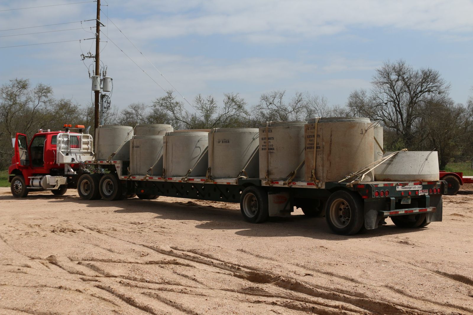 Manhole risers loaded on a Del Zotto flatbed
