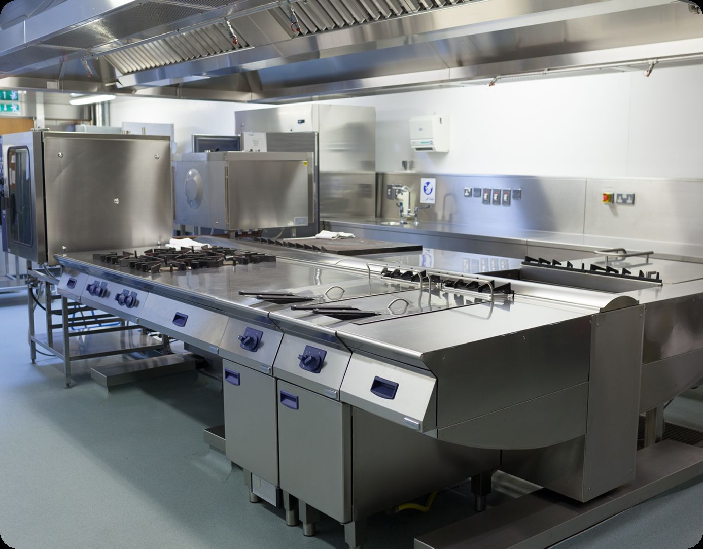 Commercial kitchen with fire suppression system above the cook line