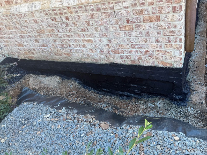 Gravel backfill. Drainage stone against the sealed wall.