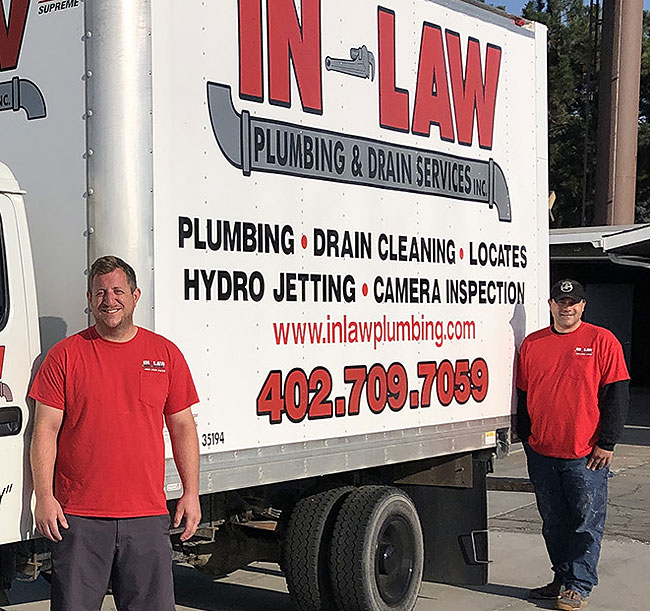 Owners Bernie Vacek and Scott Mitchell Jr. standing in front of the In-Law Plumbing box truck