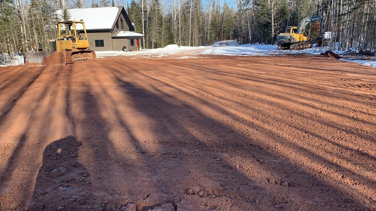 Freshly graded garage pad with dozer and excavator
