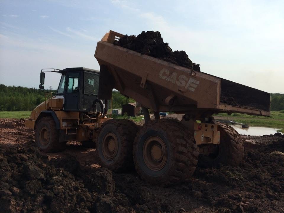 Loaded articulated hauler moving material