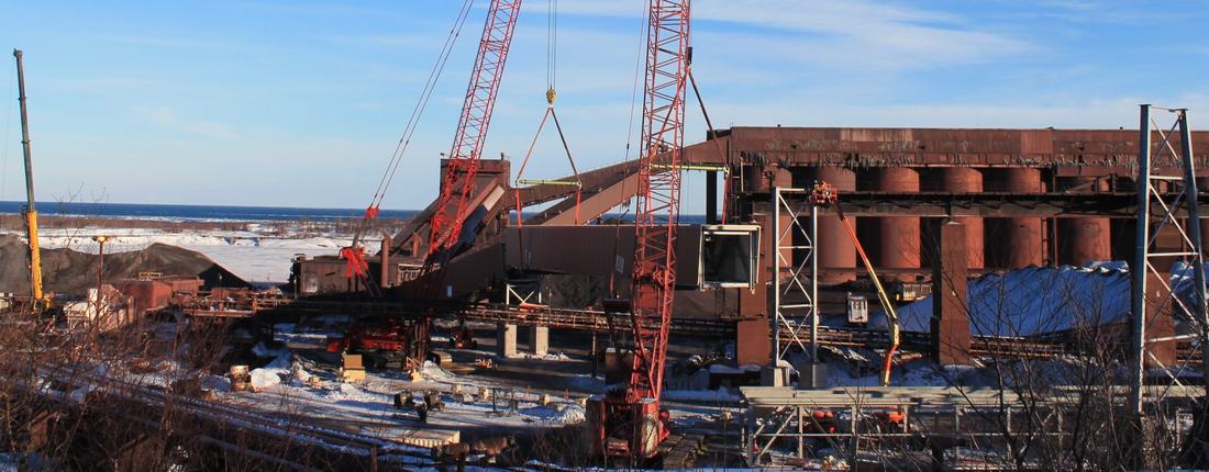 Lakehead Constructors crews setting conveyor sections with crane support in winter conditions