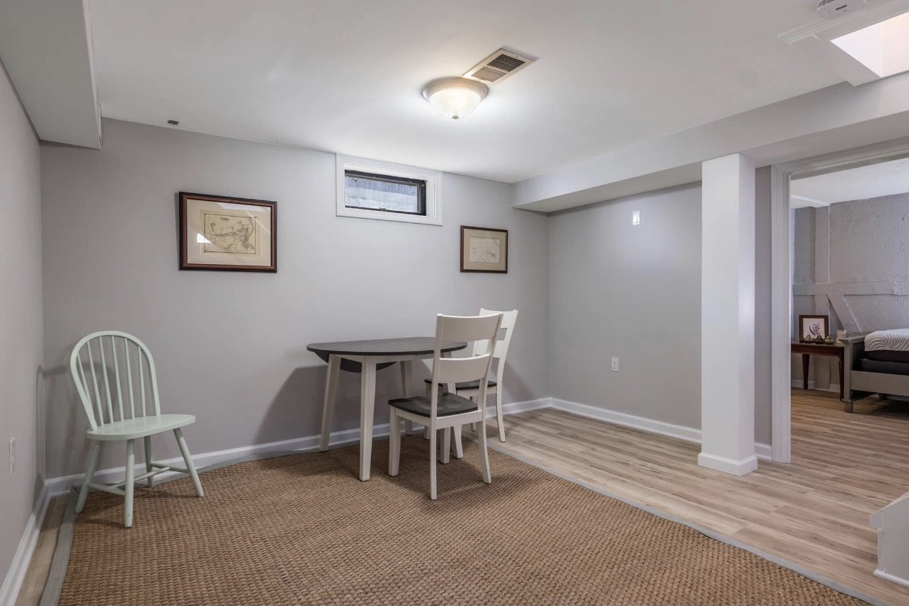 Finished lower-level living space with recessed lighting and a dining area
