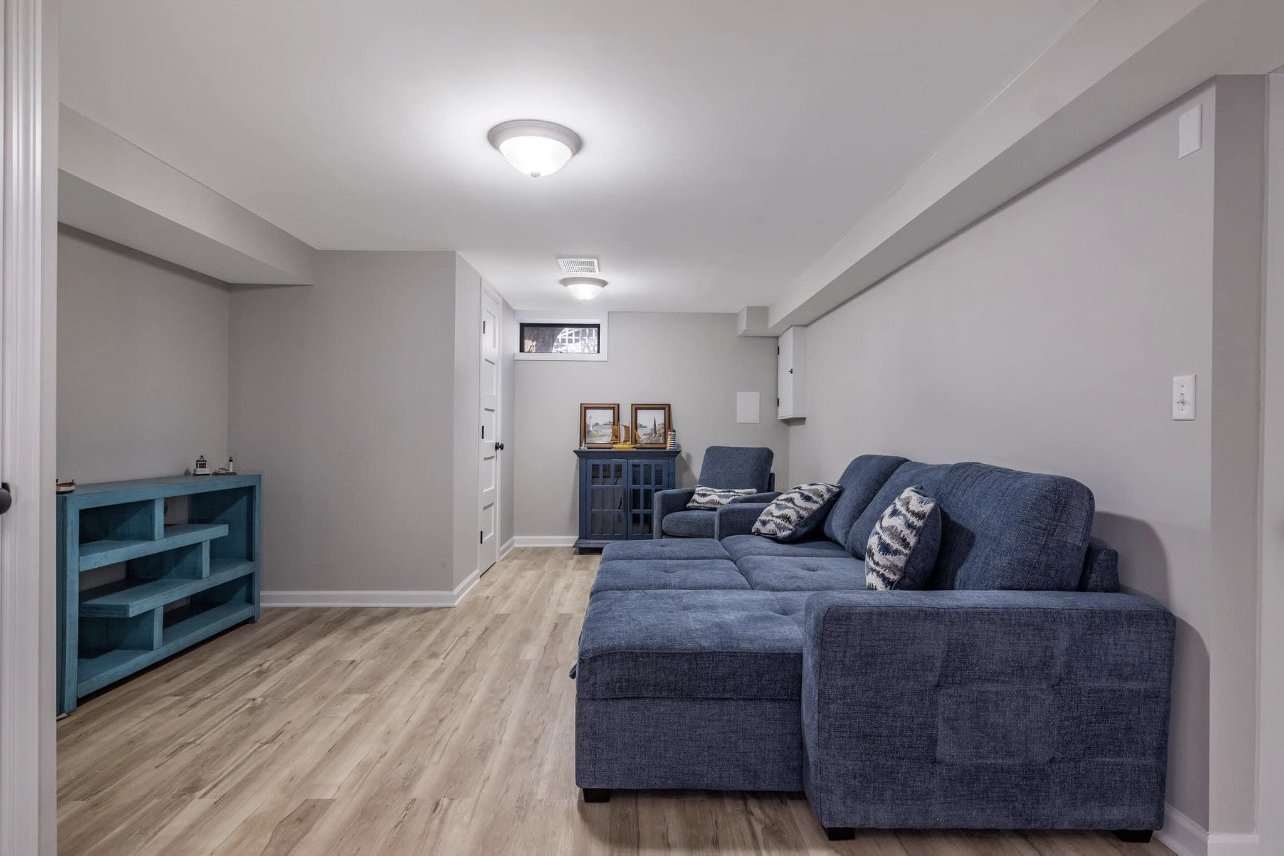 Finished lower level with a sectional sofa and new flooring