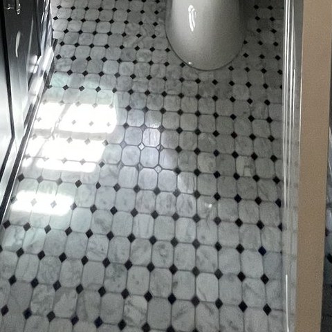 Marble octagon and dot floor tile set in a finished powder room