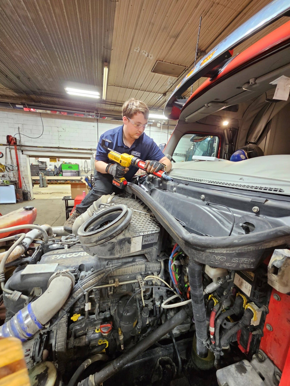 SGI technician setting a windshield on a semi tractor