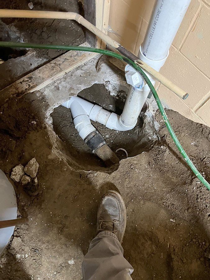Rebuilt PVC drain assembly in a basement floor