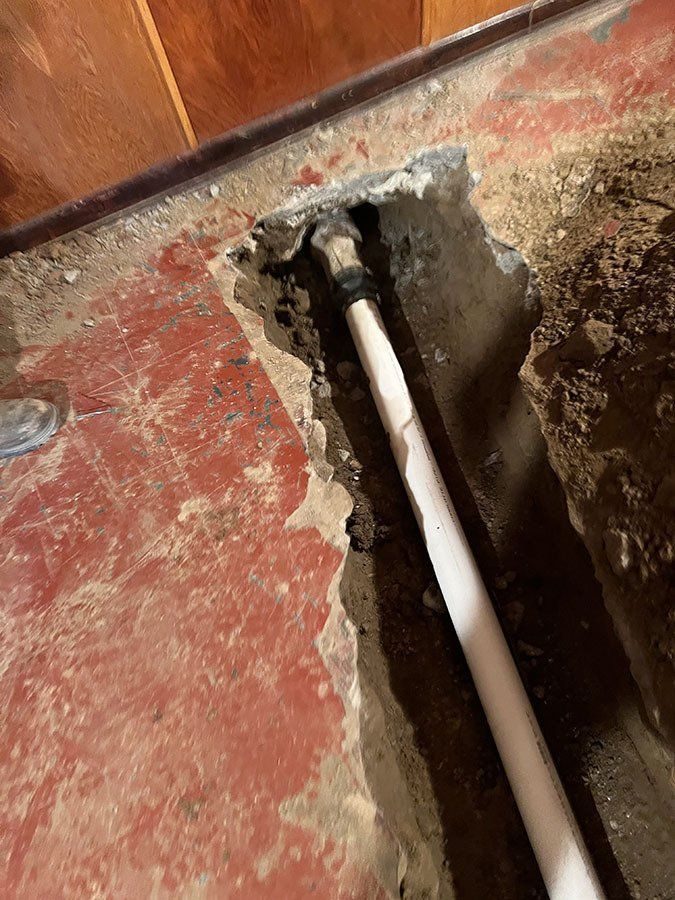 New supply line run beneath a broken-out interior floor